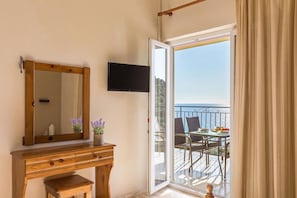 Enjoy a room with a dresser, flat-screen TV, and balcony offering a view of the sea.
