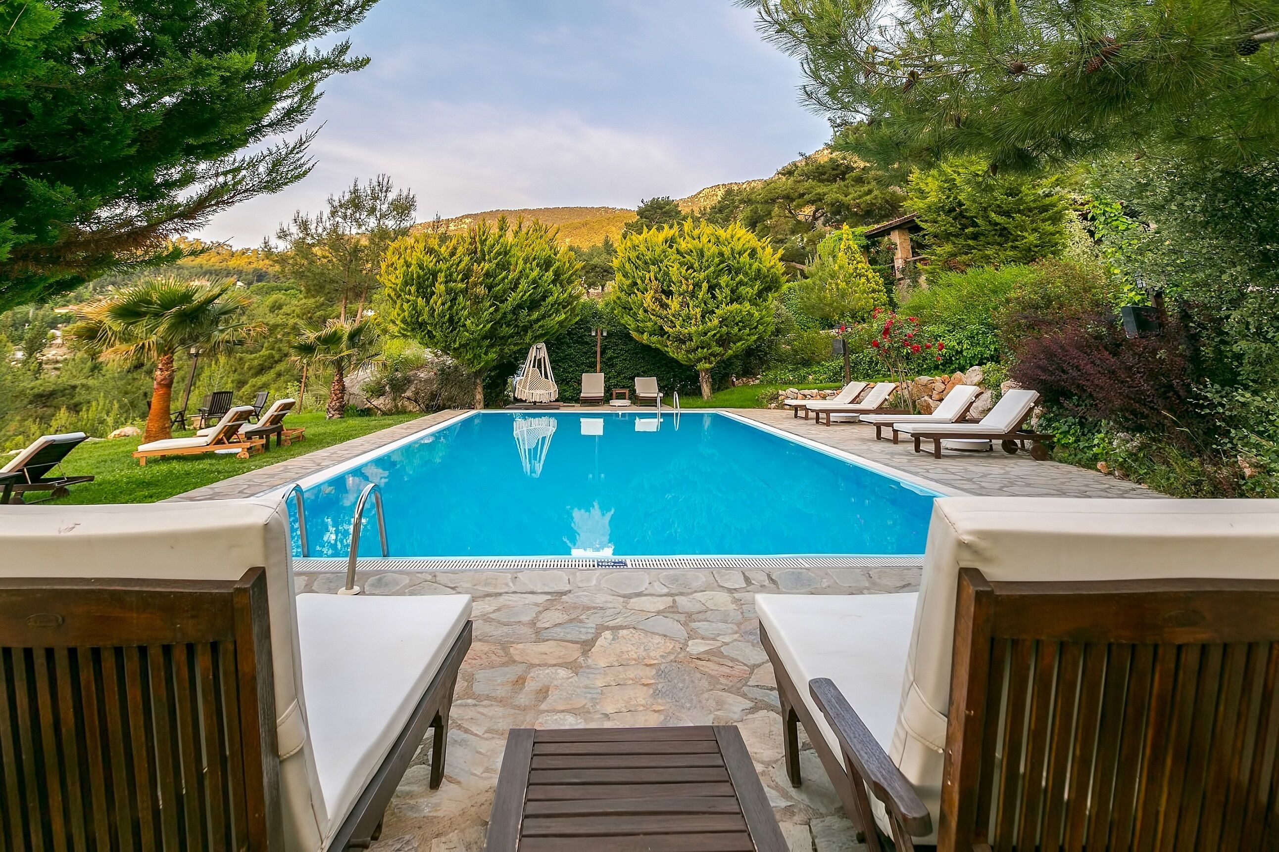 Una piscina al aire libre, sillones reclinables de piscina
