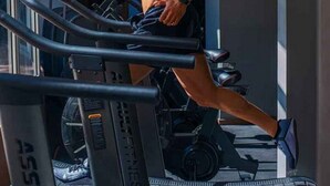 A man running on a treadmill in a gym with a window and a door in the background. - Room-aerol Hotel and Suites -super Suite (Lagos)
