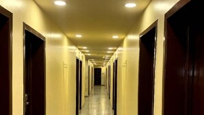 A long, well-lit hallway with doors on both sides, leading to individual rooms. - Room-aerol Hotel and Suites -super Suite (Lagos)