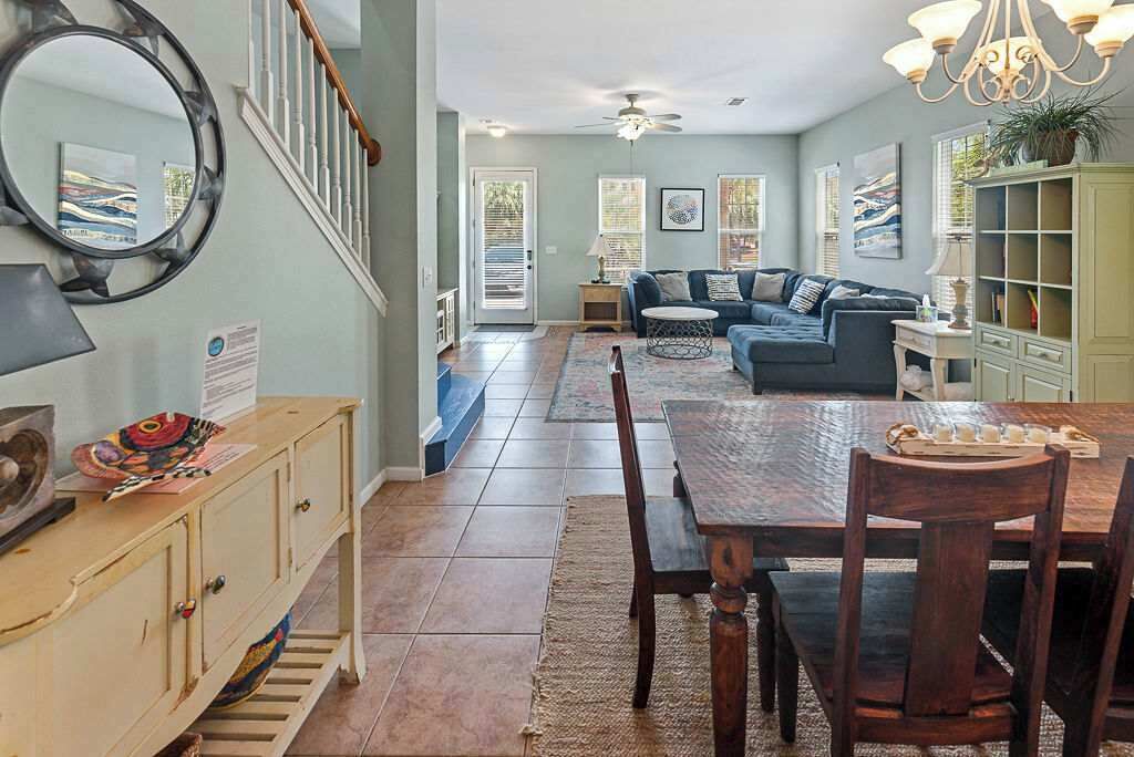 A spacious living area with a wooden dining table, a sofa, and a bookshelf.