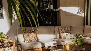 A cozy living area with a sofa, coffee table, and wicker furniture. - Hotel Estepona Plaza (Estepona)