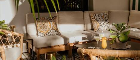 A cozy living area with a sofa, coffee table, and wicker furniture.