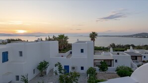 A coastal view with white buildings, a sunset, and a body of water. - Beach House With Seaview (Naxos)