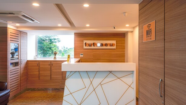 A reception area with a wooden counter, a sign reading "fourth avenue," and a WiFi symbol. - Treebo Fourth Avenue (Chennai)