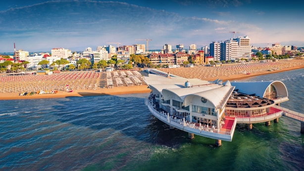 Hotel à beira-mar com um amplo deque, vários níveis e vista para o horizonte da cidade.