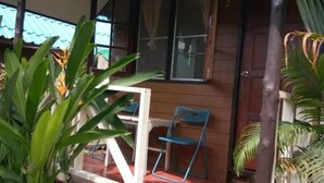 A covered outdoor area with a wooden deck, a blue mat, and a chair. - X-BAR and Bungalow (Trat)
