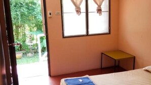 A room with a bed, a small table, and a window with curtains. - X-BAR and Bungalow (Trat)