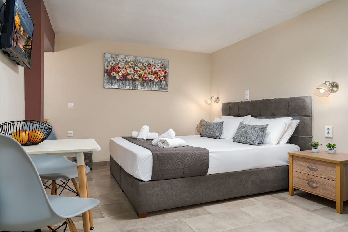 A bedroom with a bed, bedside table, and a painting on the wall.