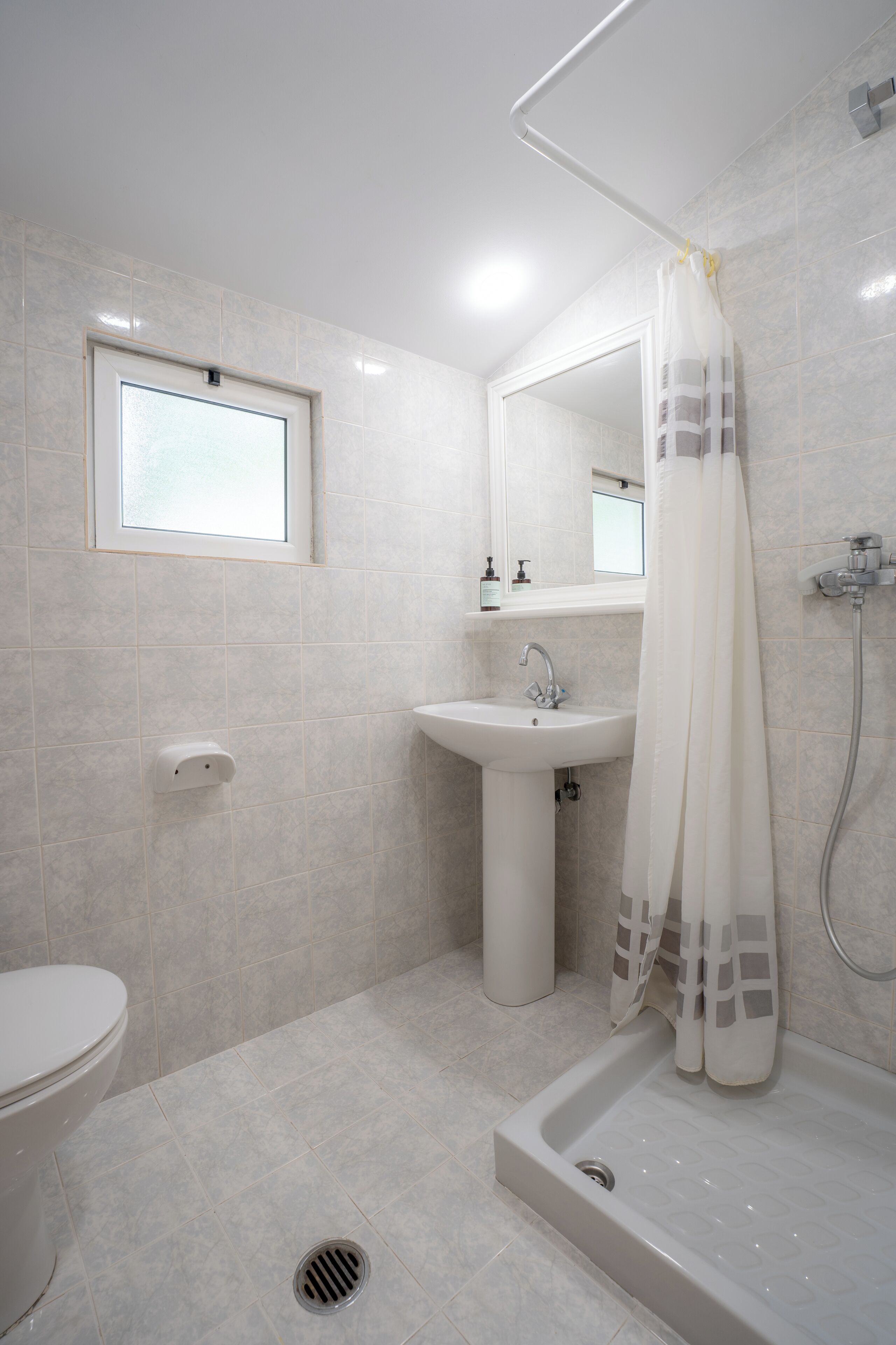 A modern bathroom with a toilet, sink, and shower area.