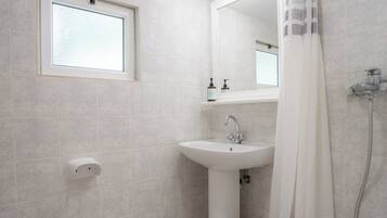 A modern bathroom with a toilet, sink, and shower area.