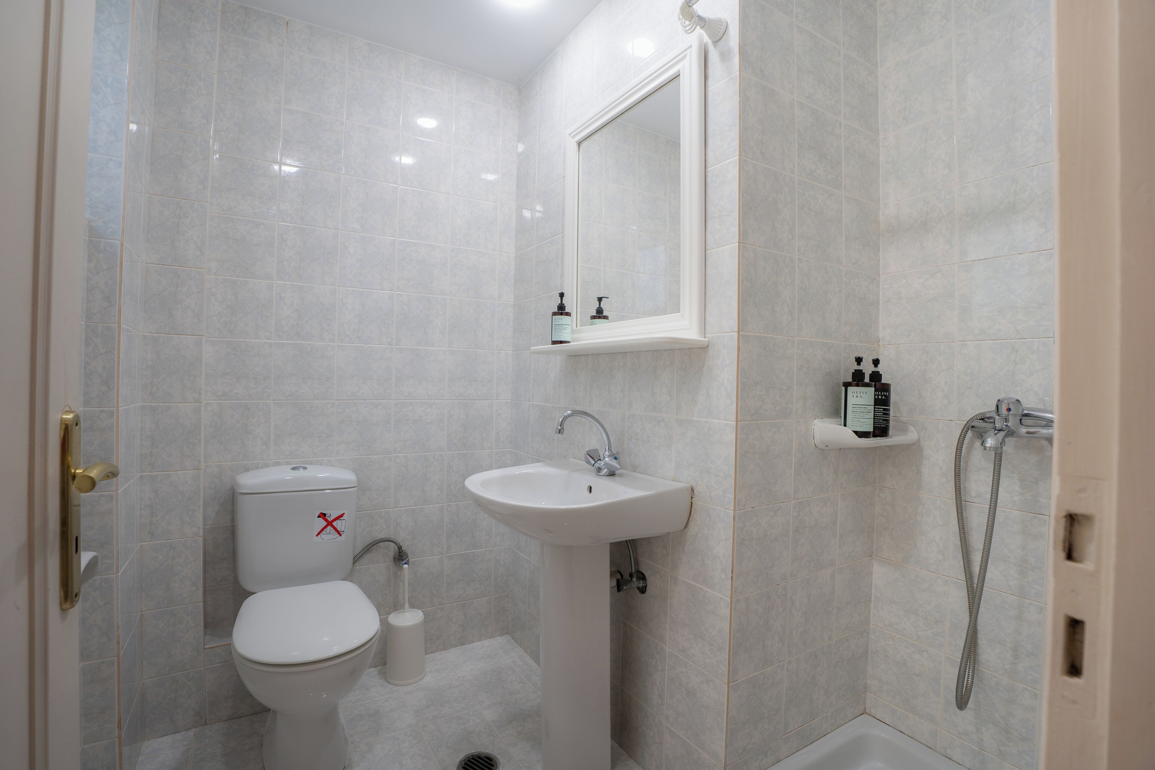 A bathroom with a toilet, sink, and shower.