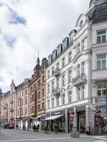 Una calle con edificios históricos, adoquinado y peatones.