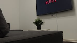 Un televisor de pantalla plana montado en la pared mostrando el logotipo de Netflix.