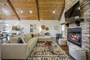 A cozy living room with a sectional sofa, a fireplace, and a dining area.