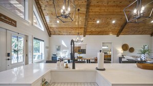 A modern kitchen with a large island, wooden ceiling, and pendant lighting. - A Rustic Cabin with a Modern Twist w Hot Tub,Fire Pit,Fireplace,Near Lake Sleep7 (Broken Bow)