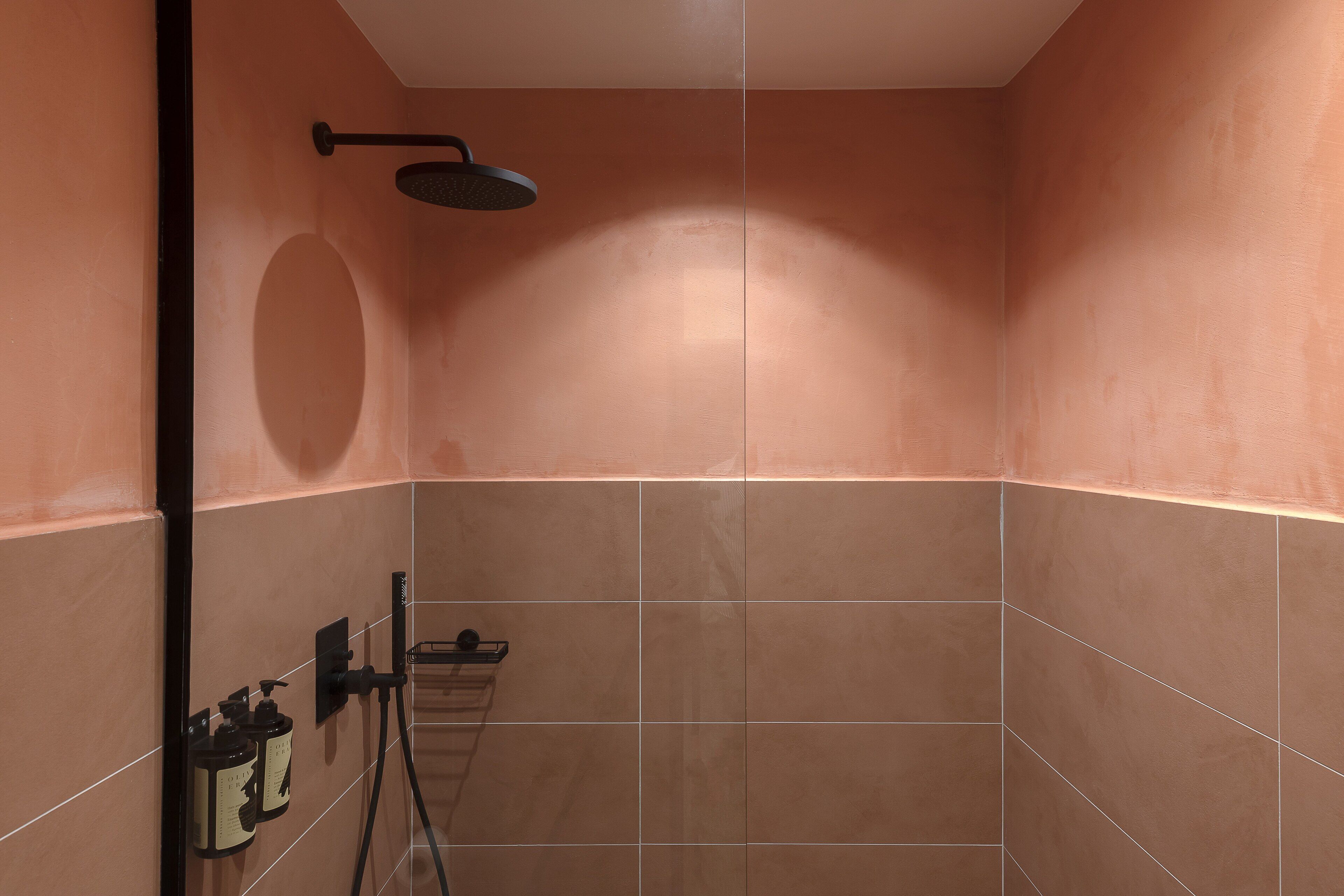 A bathroom with a shower, tiled walls, and a towel rack.