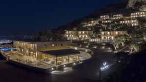 A hotel with multiple buildings, outdoor seating, and a pool area.