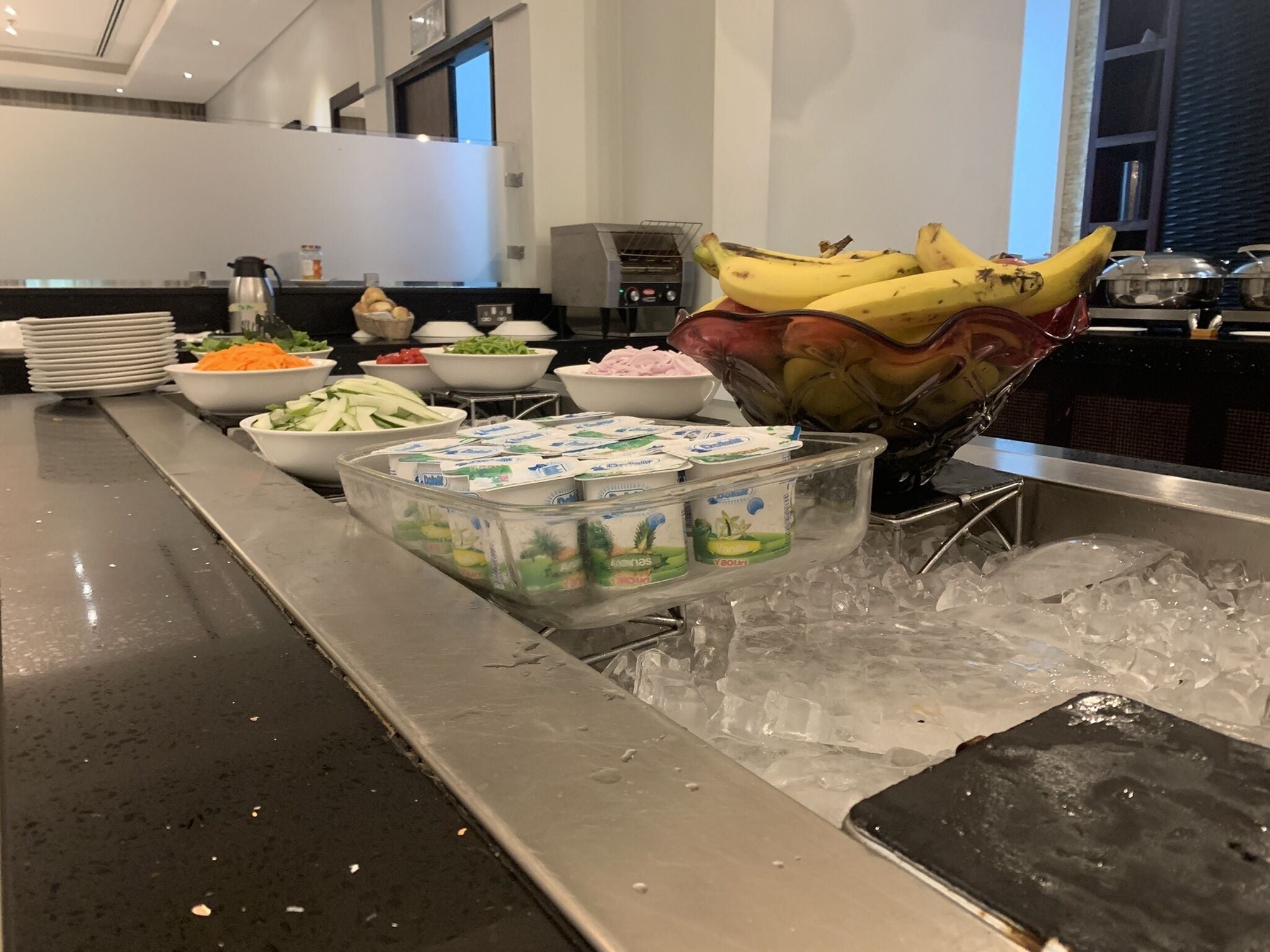 Een buffetopstelling met verschillende soorten eten en een bak ijs.