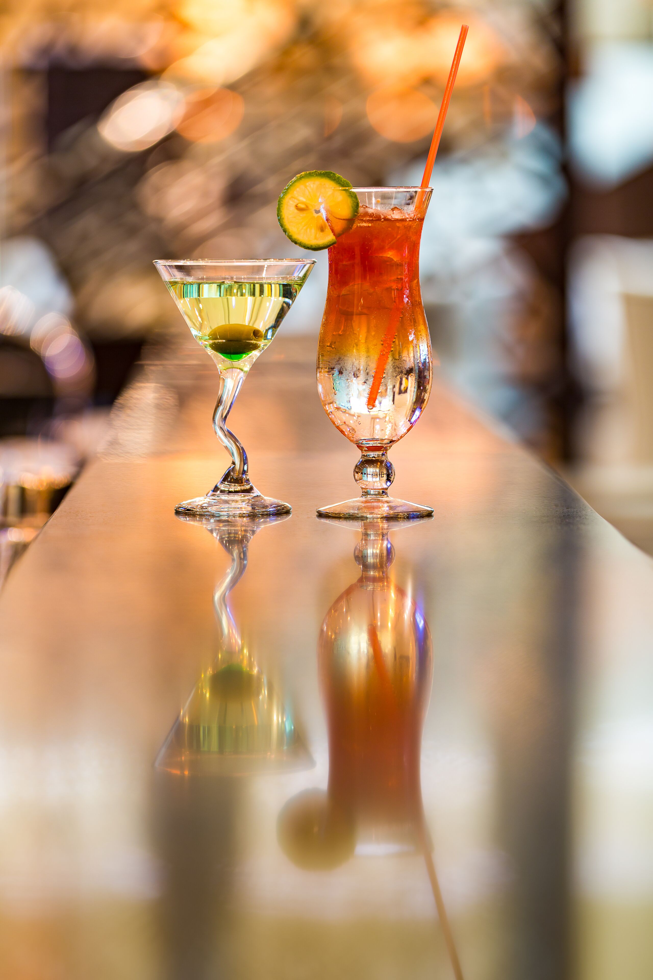 Twee cocktails op een glanzende bar.