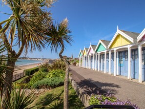 A row of colorful seaside cottages with a beach view. - Anchors Away (Weymouth)
