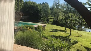 Un espacio al aire libre cubierto con una piscina, rodeado de exuberante follaje y árboles.