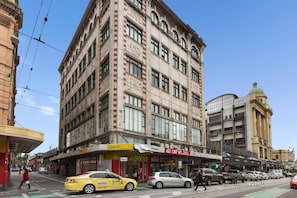 A multi-story building with a prominent 'Love and Lewis' sign, a Chemist store, and a '50% off' sale sign.