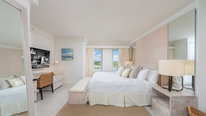 Un dormitorio moderno con una cama grande, un escritorio y vistas al exterior.