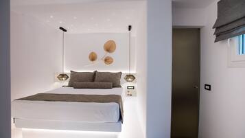 Un dormitorio moderno con una cama grande, iluminación montada en la pared y un elemento decorativo en la pared.