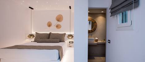 A modern bedroom with a large bed, bedside lamps, and a wall-mounted light fixture.