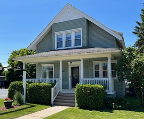 A two-story house with a front porch, a covered entryway, and a number '231' on the door.