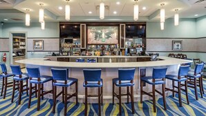 A bar area with a curved counter, multiple bar stools, and overhead lighting. - 8BR Gaming Retreat, Pool & Theatre + 1 Night Free (Champions Gate)