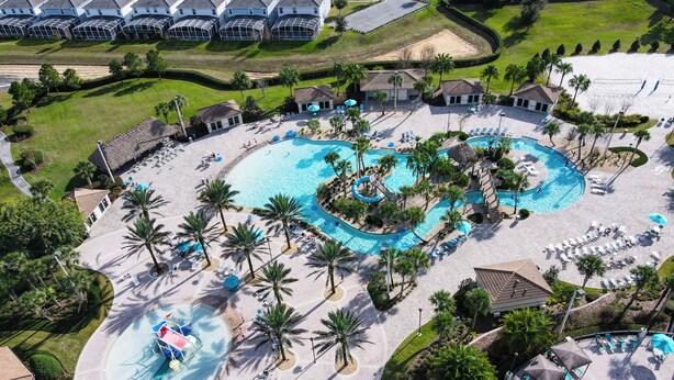 An aerial view of a resort with multiple swimming pools, palm trees, and lounge areas. - 8BR Gaming Retreat, Pool & Theatre + 1 Night Free (Champions Gate)
