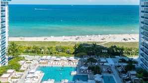 A resort with a large pool, beach, and ocean view.
