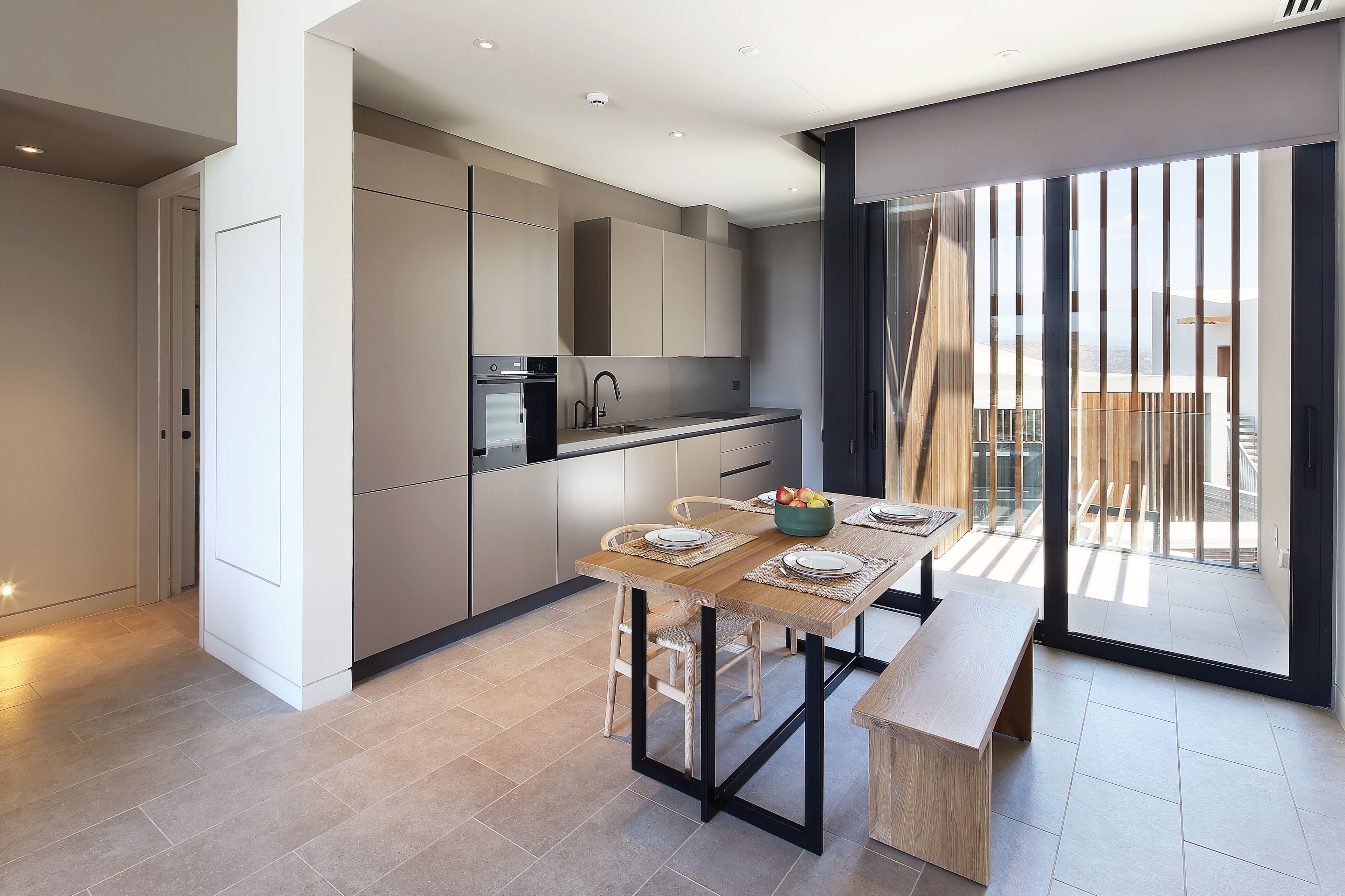 Una cocina moderna con comedor, que cuenta con un amplio ventanal y vistas a la ciudad.
