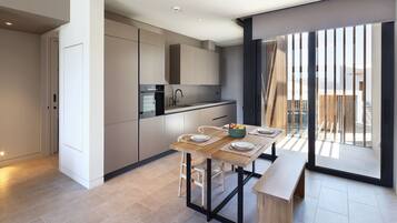 Una cocina moderna con comedor, que cuenta con un amplio ventanal y vistas a la ciudad.