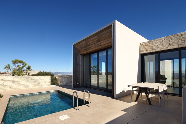 A modern outdoor pool area with a clear view of the surrounding landscape.