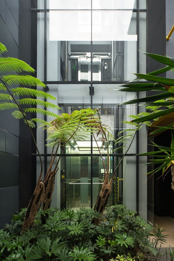 A modern building with glass walls and a central atrium. - Nindya Biodistrict Hotel (Bandung)