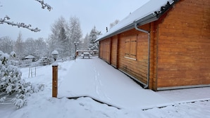 A wooden building with a covered walkway and a bench.