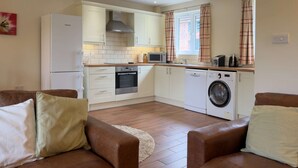 Une cuisine de taille réduite équipée d’un lave-linge, d’un four à micro-ondes et d’une cuisinière.