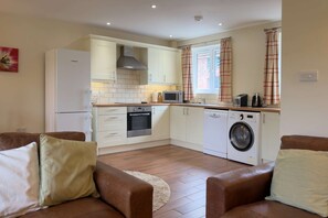 A compact kitchen with a washing machine, a microwave, and a stove.