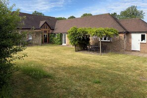 A residential property with a brick house, a wooden door, and a small patio area with outdoor furniture. - Within the South Downs National Park, 7 miles north of Brighton. (Hassocks)