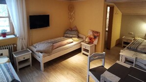 Une chambre confortable avec un lit, des tables de chevet, une chaise et un téléviseur.