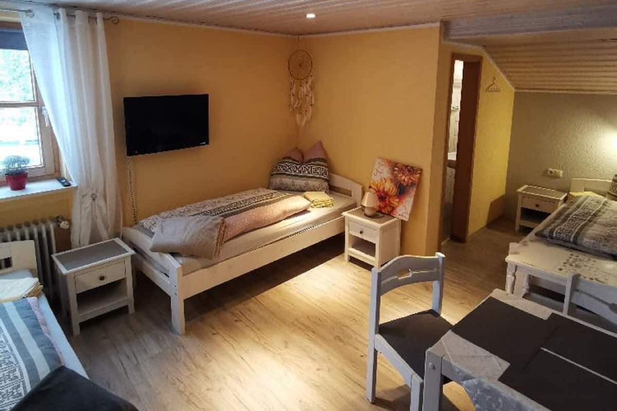 Une chambre confortable avec un lit, des tables de chevet, une chaise et un téléviseur.