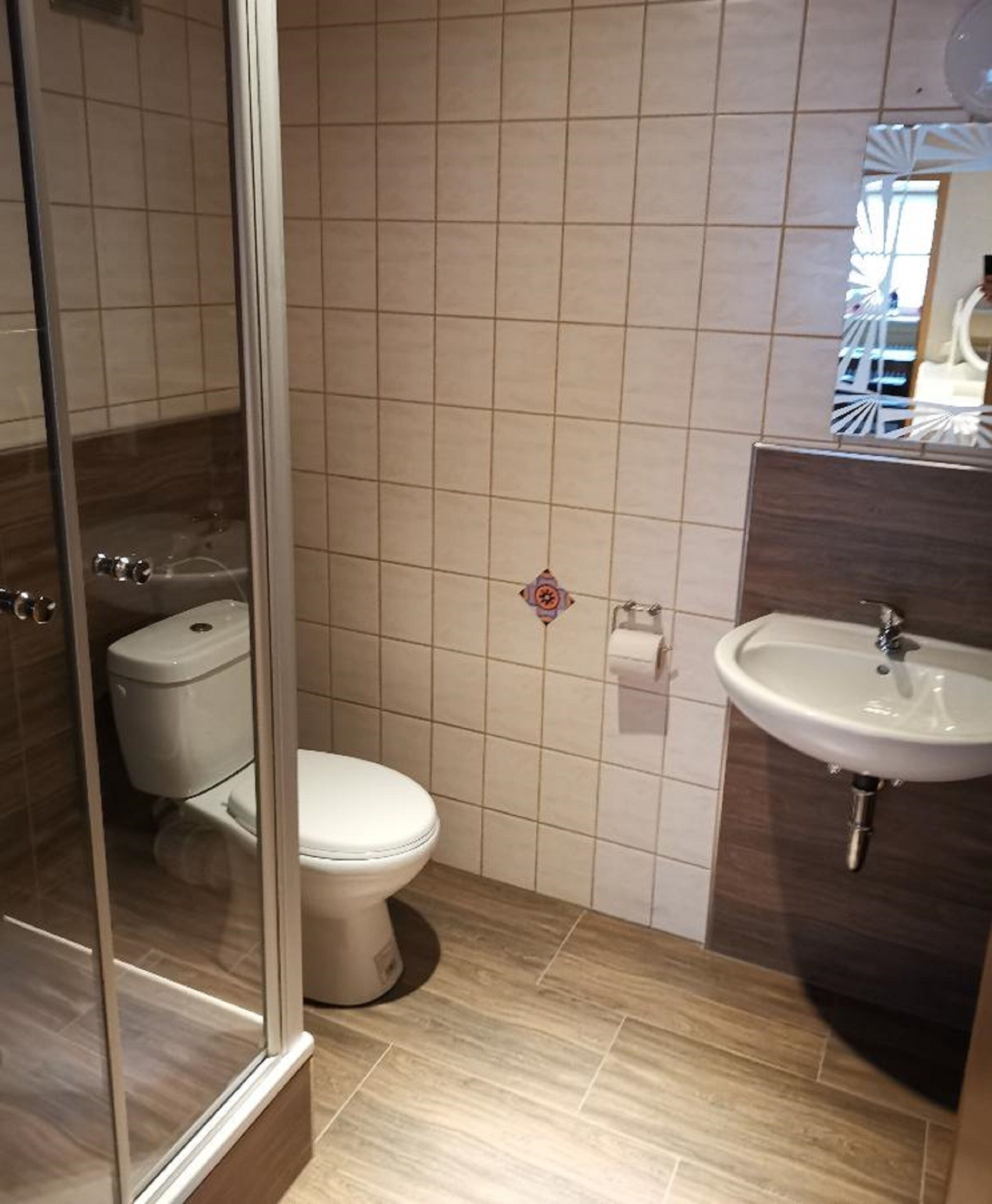 Une salle de bain comprenant des toilettes, un lavabo et un espace douche.