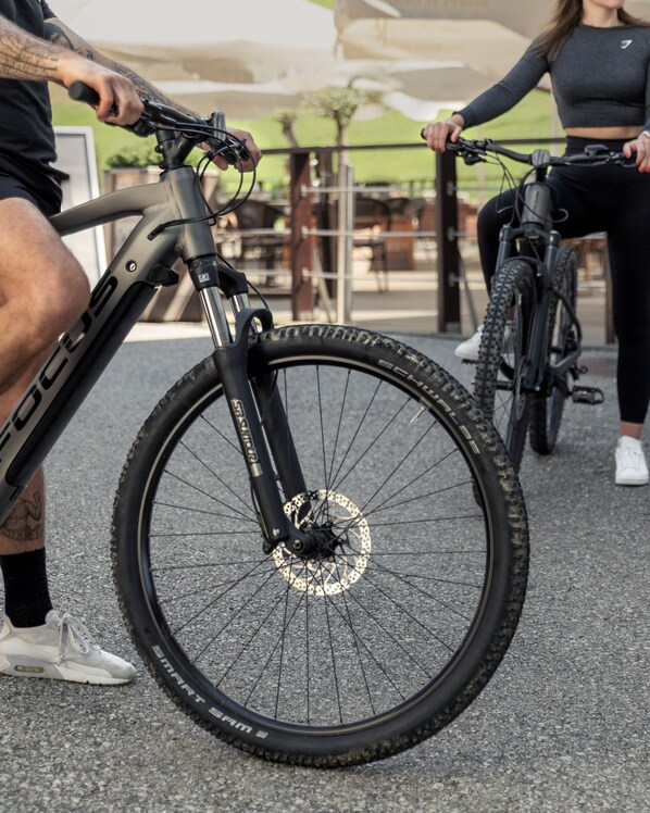 A close-up of a bicycle with a black frame and a disc brake wheel.