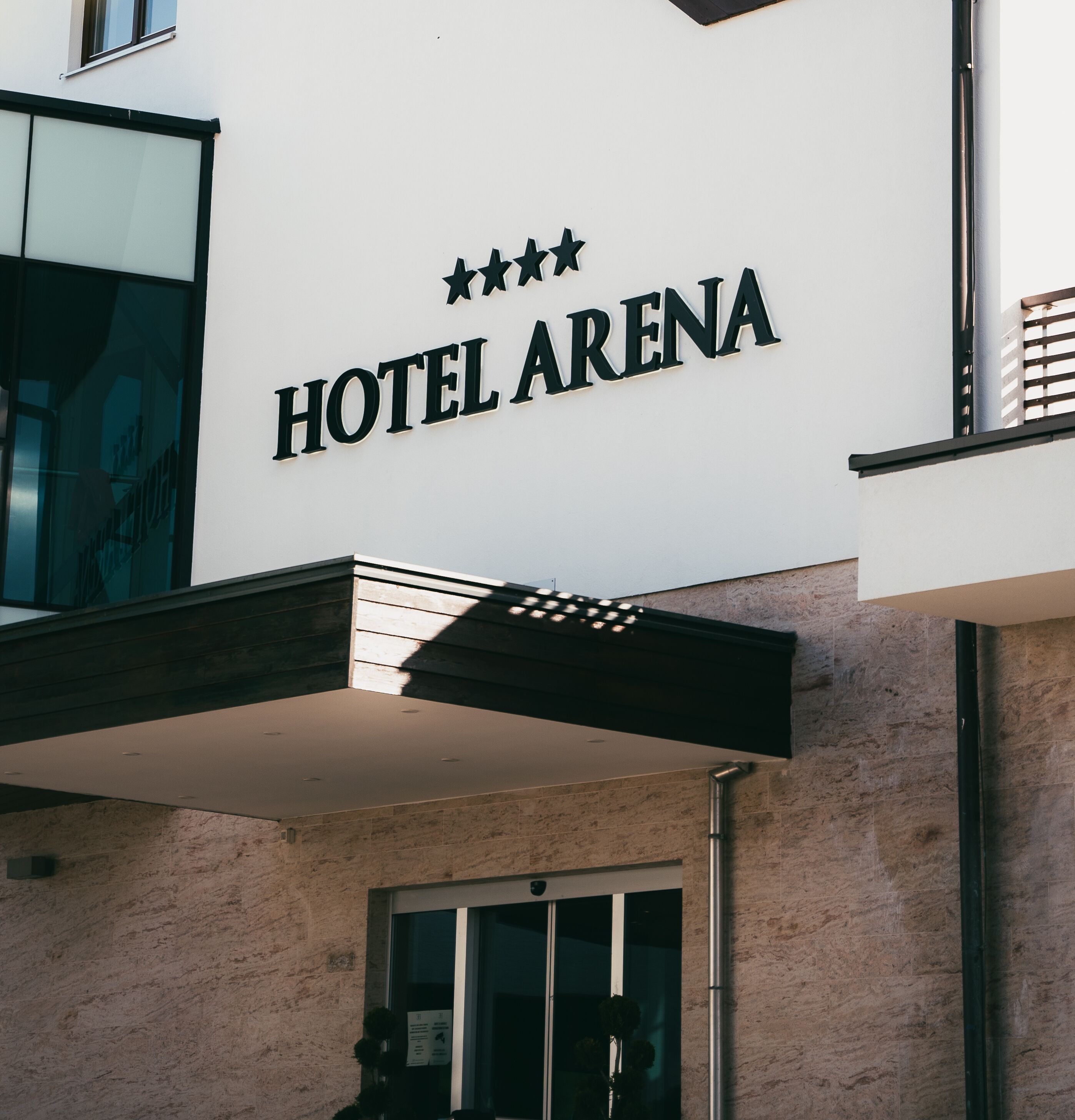 A hotel sign with "HOTEL ARENA" and three stars.