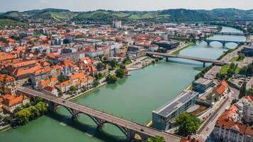 A cityscape with multiple bridges over a river, surrounded by buildings with red-tiled roofs.