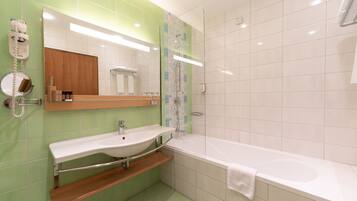 Un baño moderno con una bañera grande, un lavabo y un espejo.