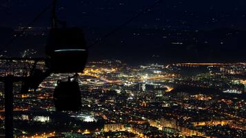Vista nocturna de un paisaje urbano desde un punto elevado, con edificios e iluminadas calles.